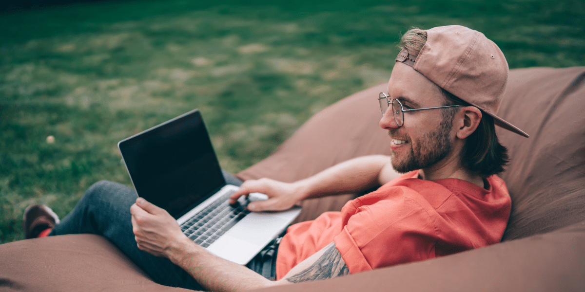 young man using his laptop while sitting on a beanbag