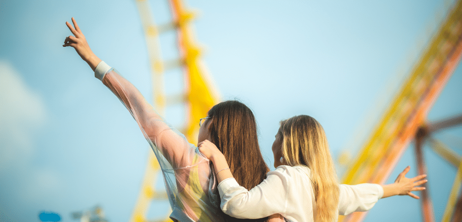 picture of 2 girls in front of a ride at a festival in oklahoma